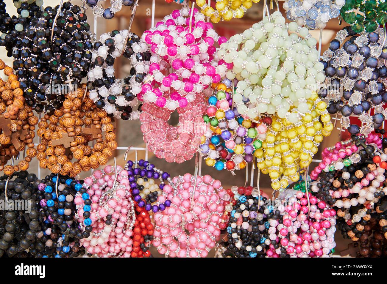 Nahaufnahme einer Anzeige mit farbigen Rosarmbändern aus Kunststoff und Holzwullen, die von einem Anbieter während des Ati-atihan Festivals auf den Philippinen zum Verkauf angeboten werden Stockfoto