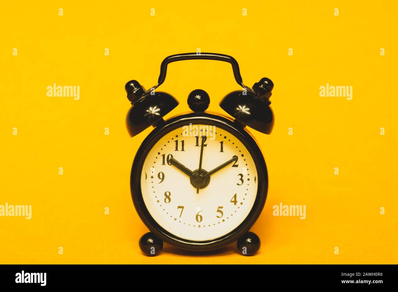 Klassischer Wecker auf gelbem Hintergrund. Vintage-Uhr mit Runduhr. Kopierbereich Stockfoto