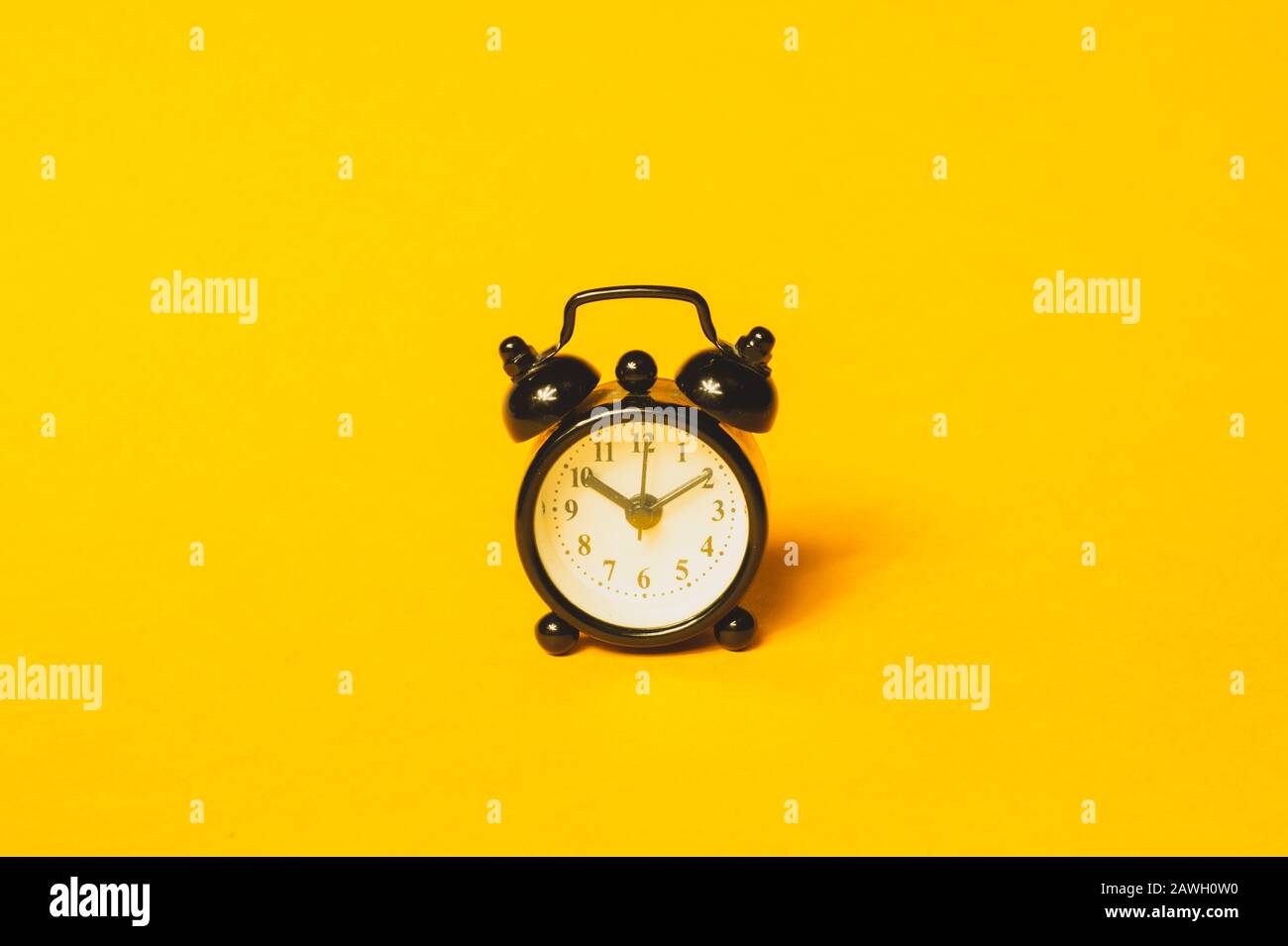 Klassischer Wecker auf gelbem Hintergrund. Vintage-Uhr mit Runduhr. Kopierbereich Stockfoto