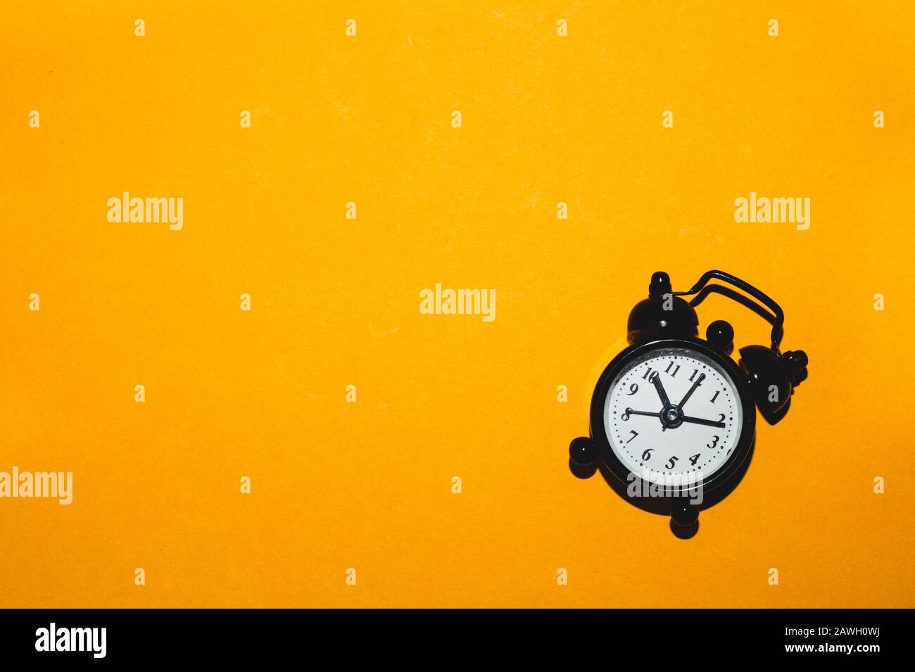 Klassischer Wecker auf gelbem Hintergrund. Vintage-Uhr mit Runduhr. Kopierbereich Stockfoto