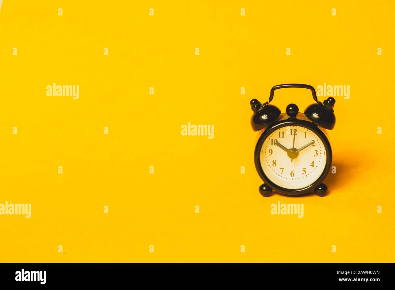 Klassischer Wecker auf gelbem Hintergrund. Vintage-Uhr mit Runduhr. Kopierbereich Stockfoto