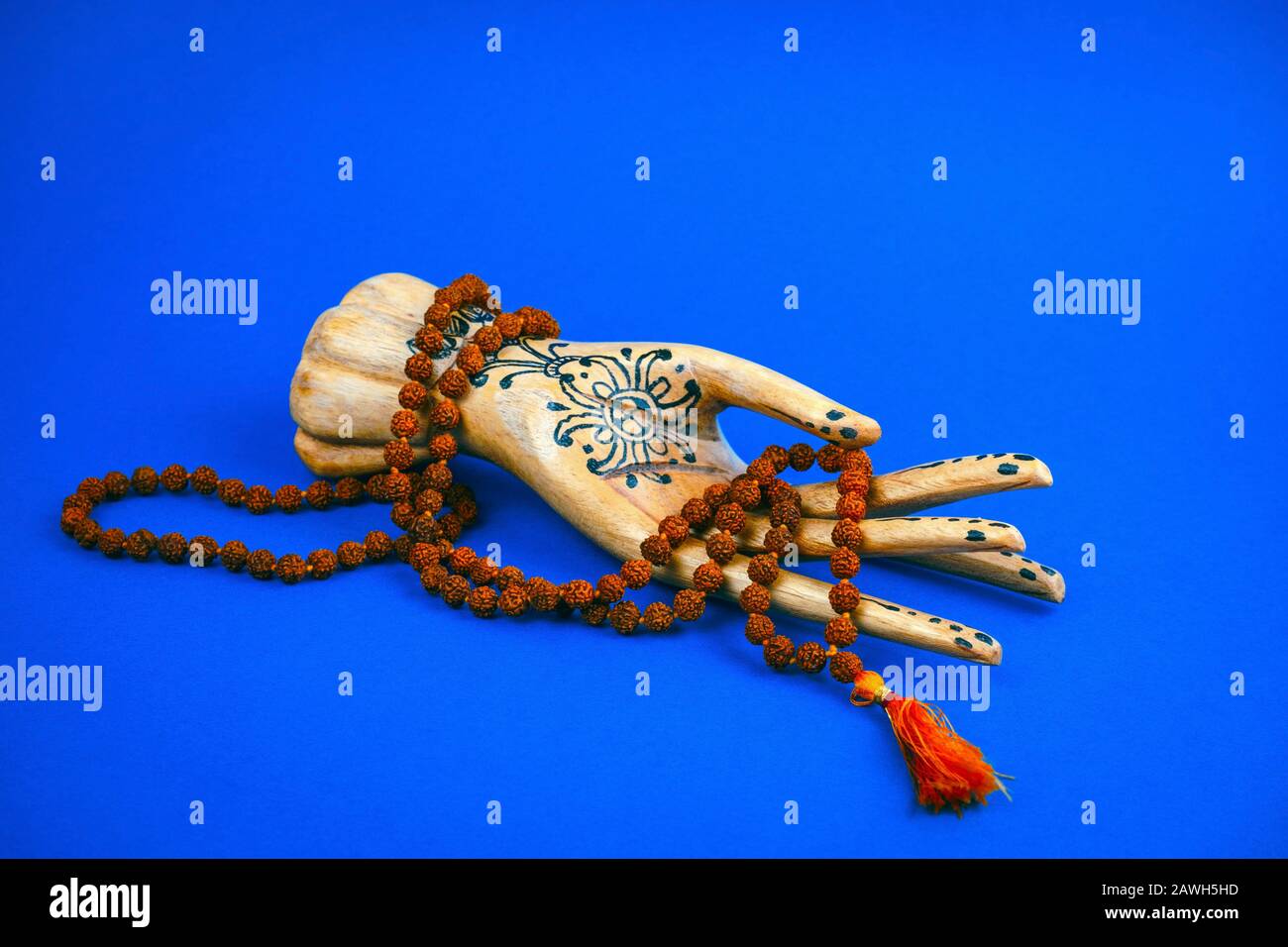 Holzhand hält einen Rosary auf hellblauem Grund Stockfoto