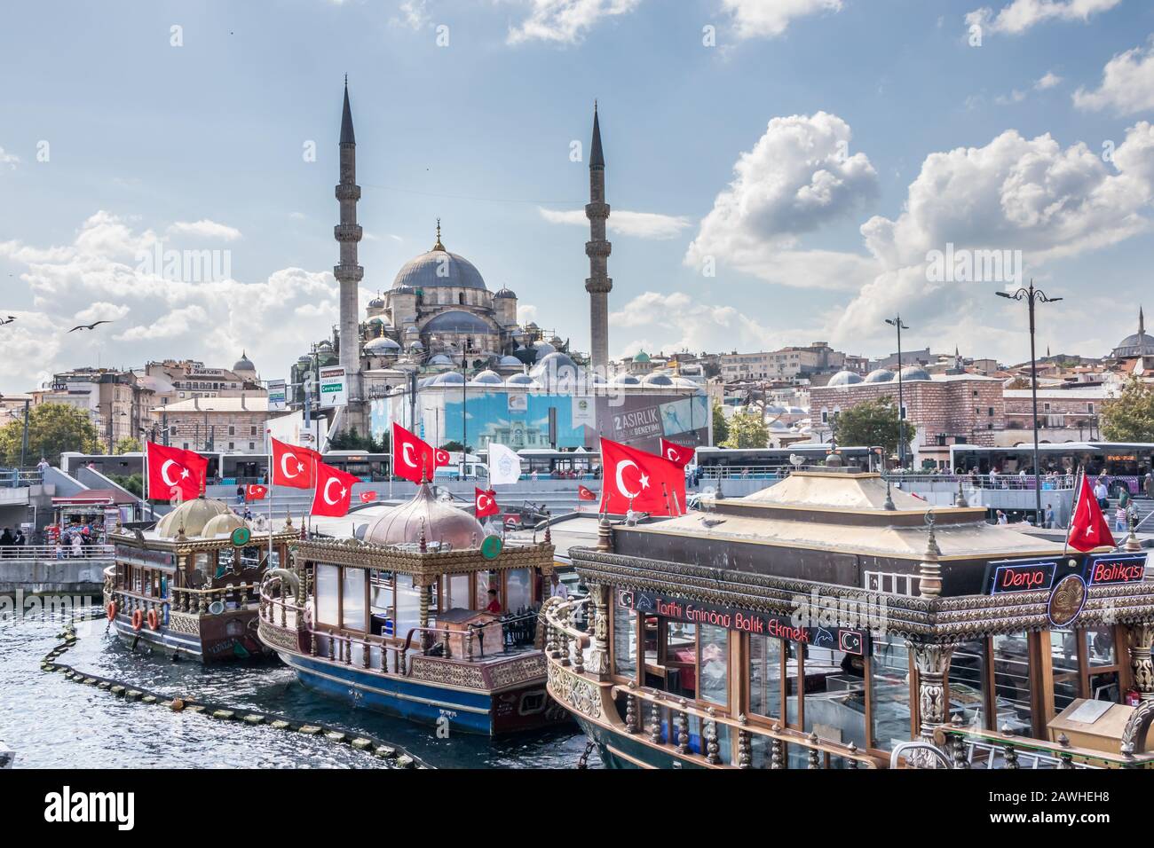 Istanbul, Türkei - 30. August 2019: Boote, die Fischbrötchen am Goldenen Horn verkaufen. Die neue Moschee steht im Hintergrund Stockfoto