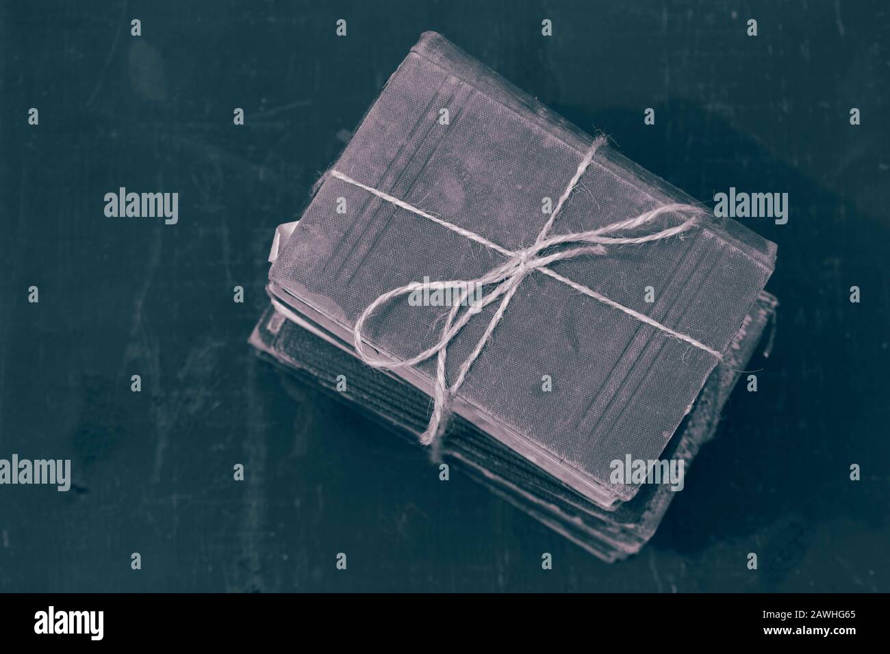 Antike alte Bücher, die in einen Haufen gestapelt sind, der mit einer Schnur verbunden ist. Mit Farbtonierung Stockfoto