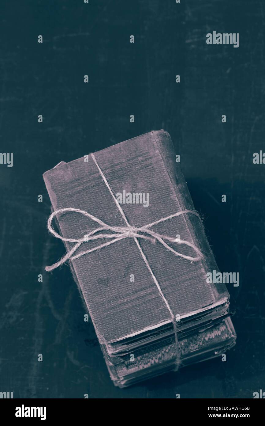Antike alte Bücher, die in einen Haufen gestapelt sind, der mit einer Schnur verbunden ist. Mit Farbtonierung Stockfoto