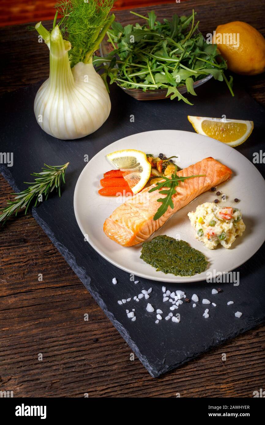 Gegrillter Lachs mit Zitrone, Kräutern und Pesto. Rote Karotten. Kartoffelsalat. Stockfoto