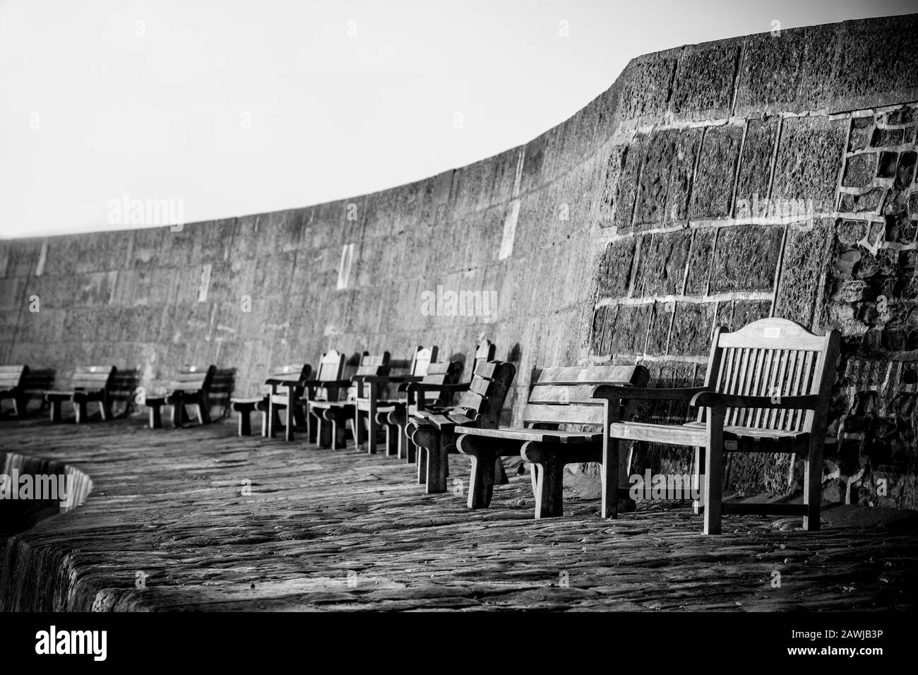 Holz-Gedenkbänke am Cobb Harbour in Lyme Regis im Februar. Dorset England GB. Stockfoto