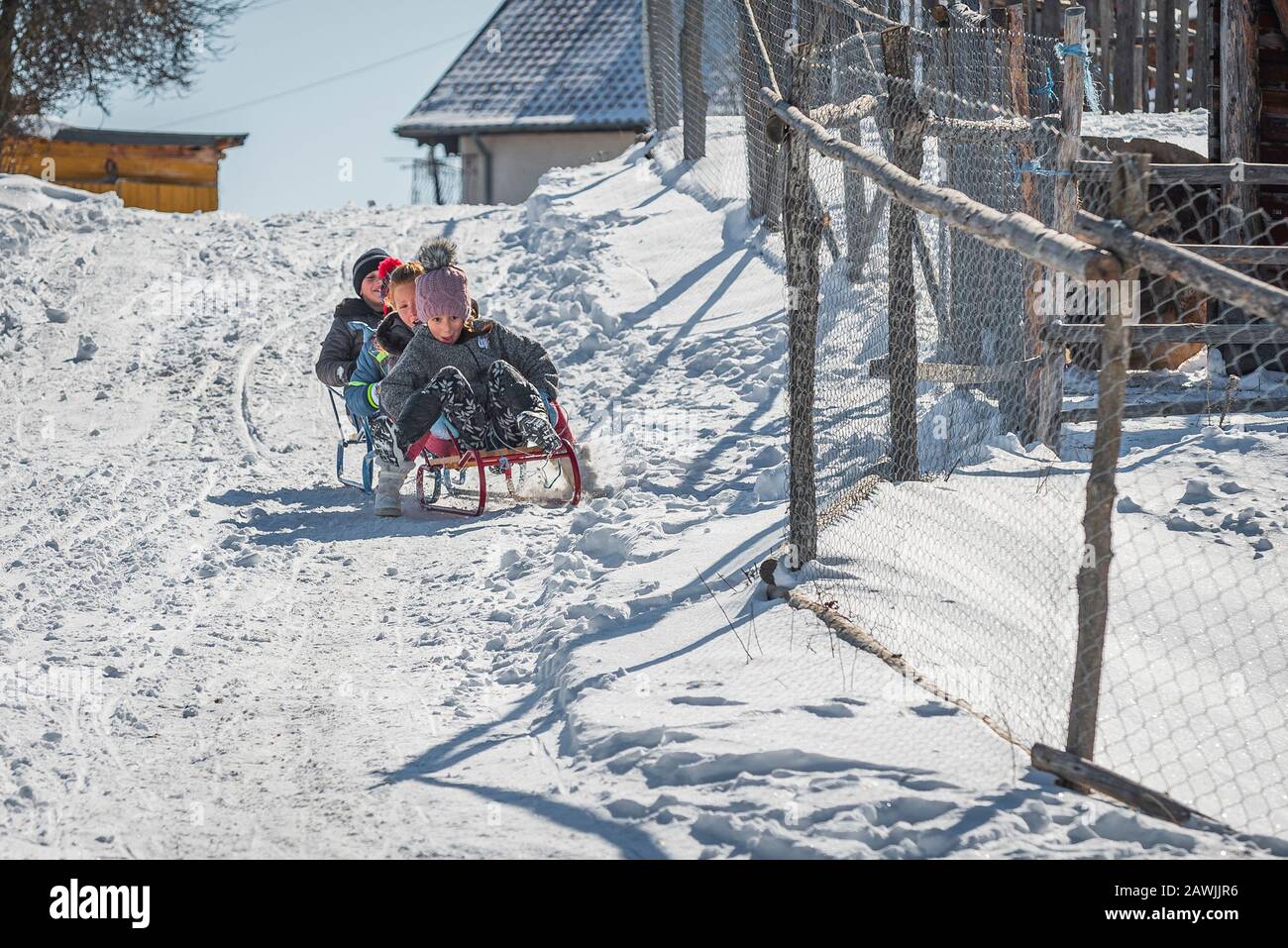 Grashevo-Dorf, Rhodopen-Gebirge, Bulgarien - 8. Februar 2020: Kleine Kinder, die im Winter Spaß am Eisrutschen haben Stockfoto