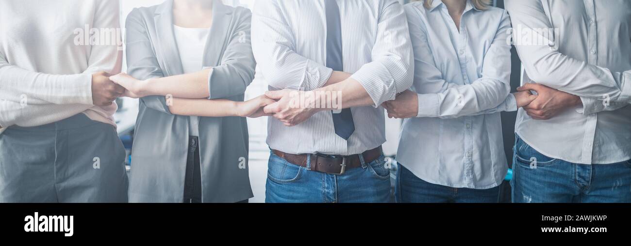 Kreative Teambesprechung verbindet sich. Junge Geschäftsleute halten sich die Hände. Einigkeit und Teamarbeit. Stockfoto