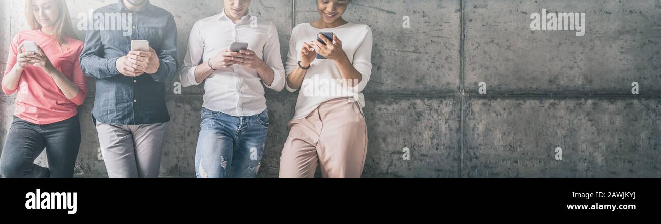 Eine Gruppe von Studenten und Freunden, die mehrere Rassen haben und Smartphones ansehen. Neuer Technologietrend. Stockfoto
