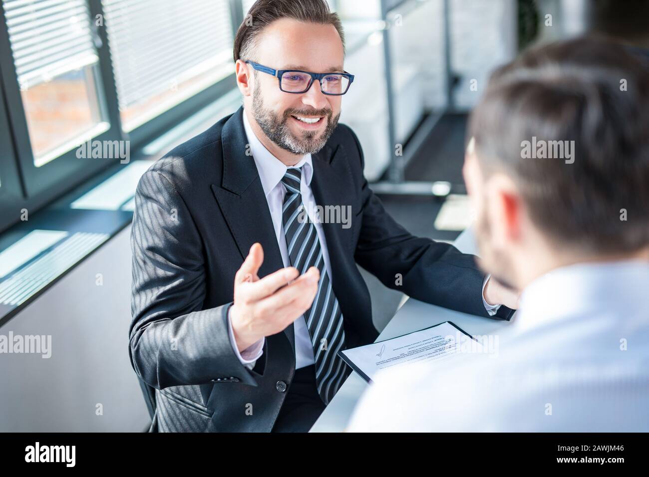 Geschäftsleute, die einen Vertrag aushandeln. Menschliche Hände, die mit Dokumenten am Schreibtisch arbeiten und einen Vertrag unterzeichnen. Stockfoto