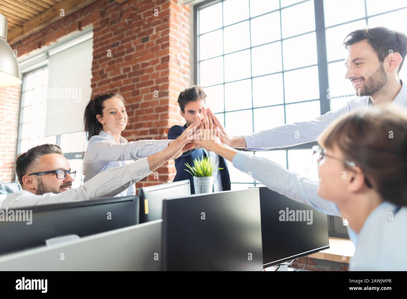 Geschäftsleute zeigen gerne Teamarbeit und geben fünf im Büro. Teamwork-Konzepte. Stockfoto