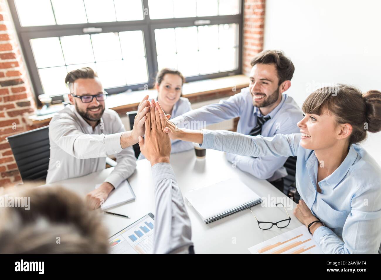 Geschäftsleute zeigen gerne Teamarbeit und geben fünf im Büro. Teamwork-Konzepte. Stockfoto