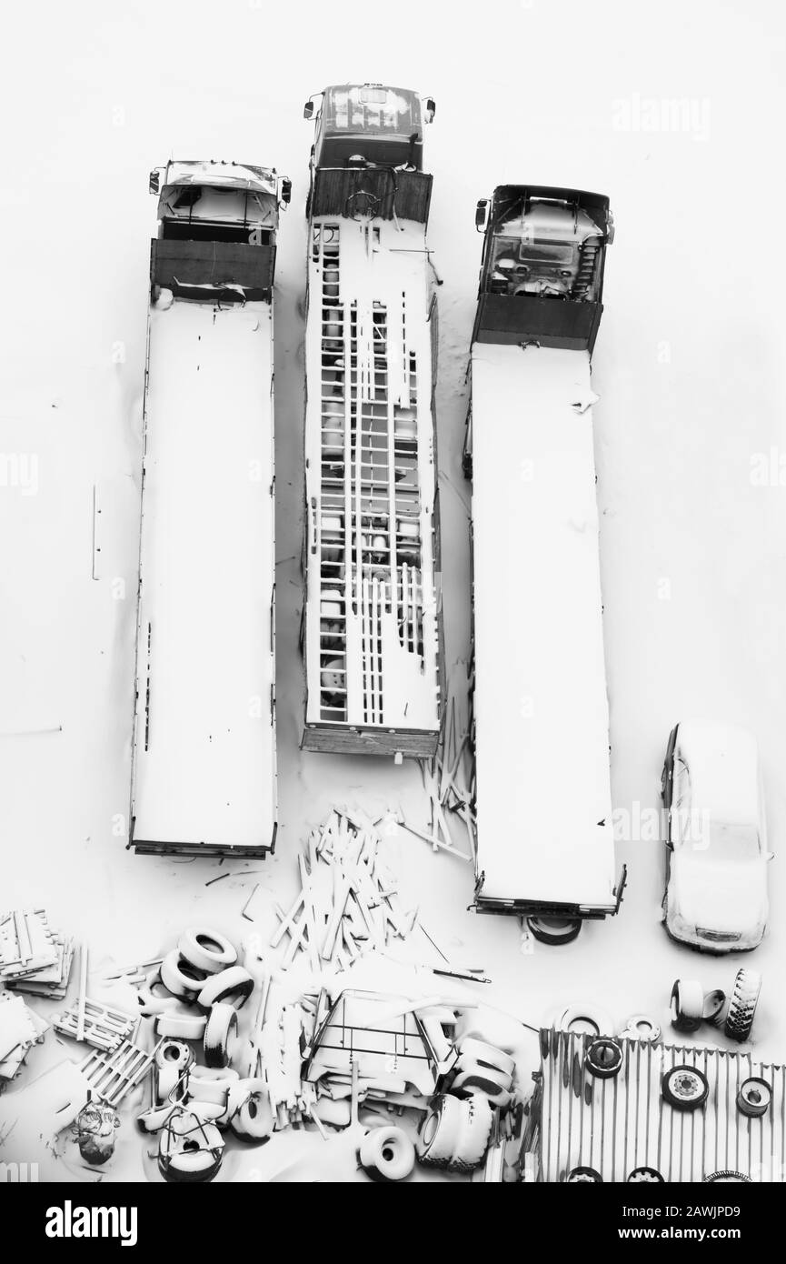 LKW unter dem Schnee. LKW nach Schneefall mit Schnee bedeckt. Lange LKWs stehen in einer Reihe Draufsicht. Transportkonzept. Schneebedeckte Fahrzeuge. Aeri Stockfoto