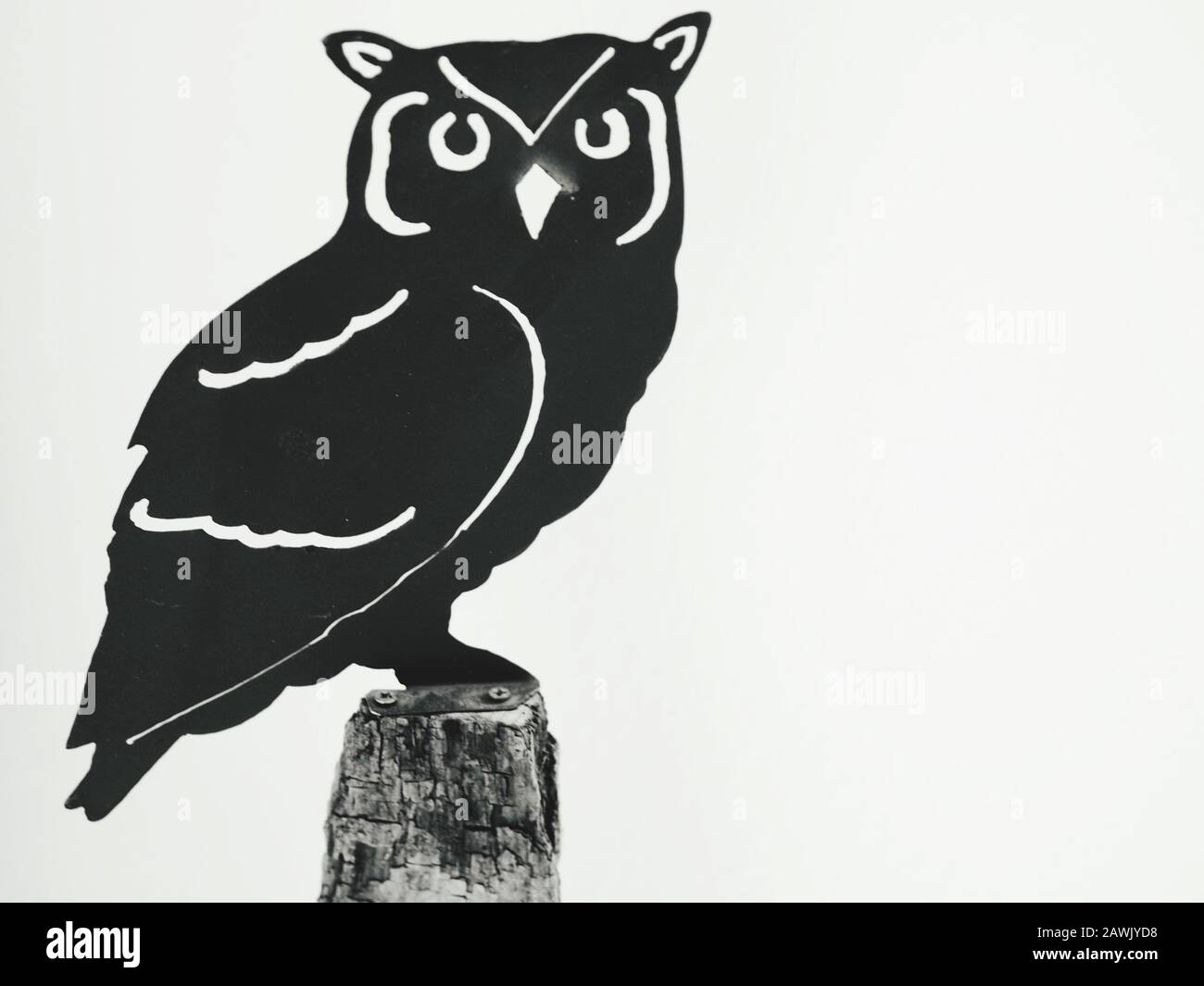 Eule, die auf Holzpfosten sitzen, arbeiten Metall als Symbol der Weisheit Stockfoto