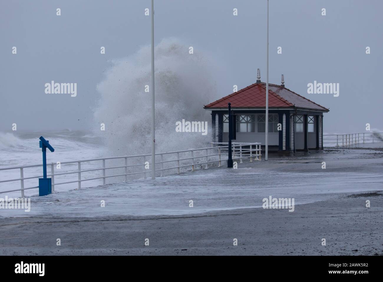 Wellen, die während des Sturms Ciara in Aberystwyth, Wales, Großbritannien, in die öffentliche Schutzhütte eintreffen Stockfoto
