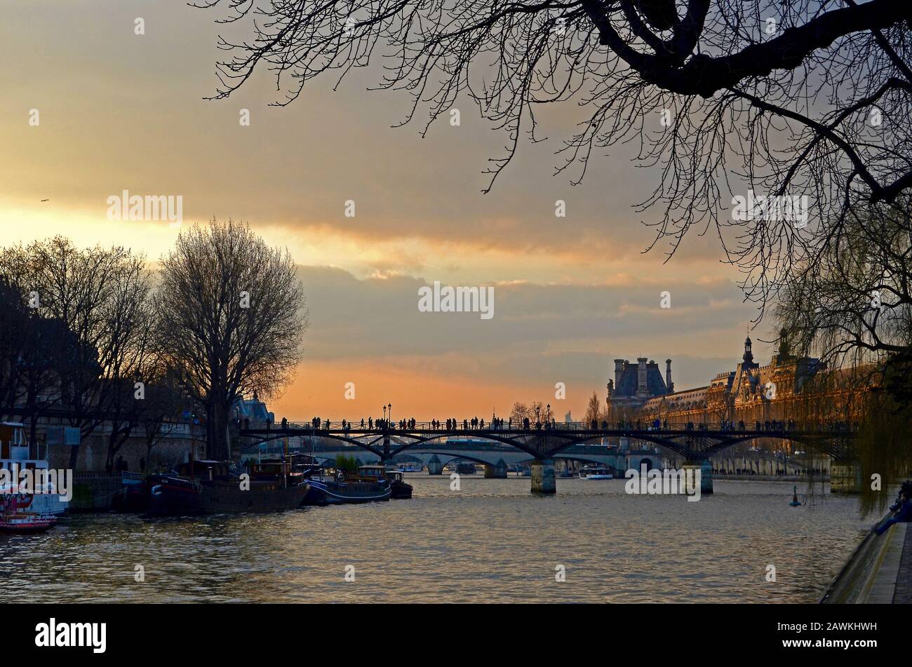 Paris, Frankreich: 17.02.2017; Silhouettenspaziergänge in der Pont des Arts in Paris. Blick vom Pont-Neuf mit dem Louvre im Hintergrund. Stockfoto