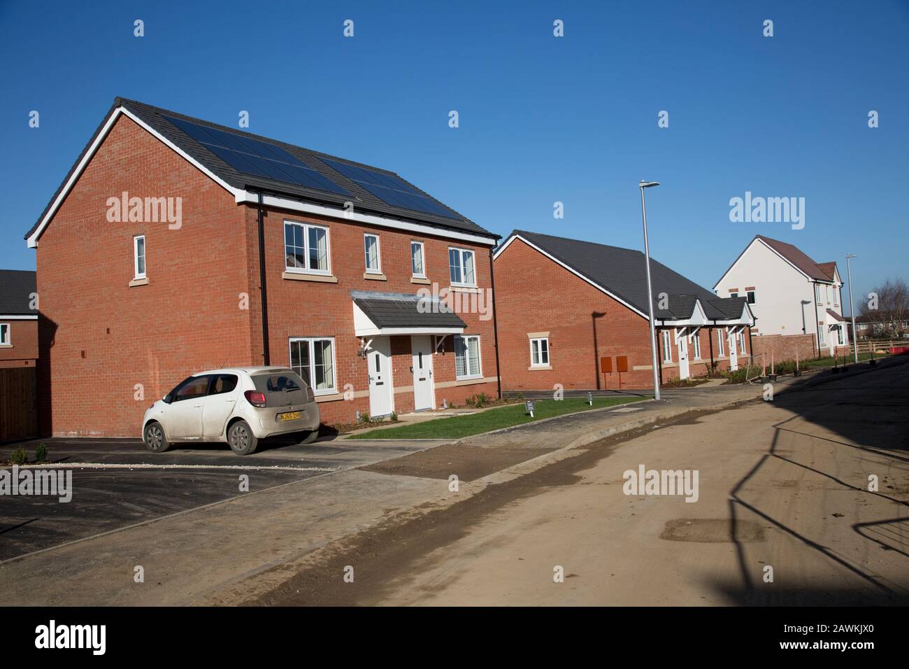 Neue rote Ziegelsteinhäuser auf kleiner, gut ausgelegter Bebauung mit Solaranlagen, die verpflichtend PM Sozialwohnungen sind. Stockfoto