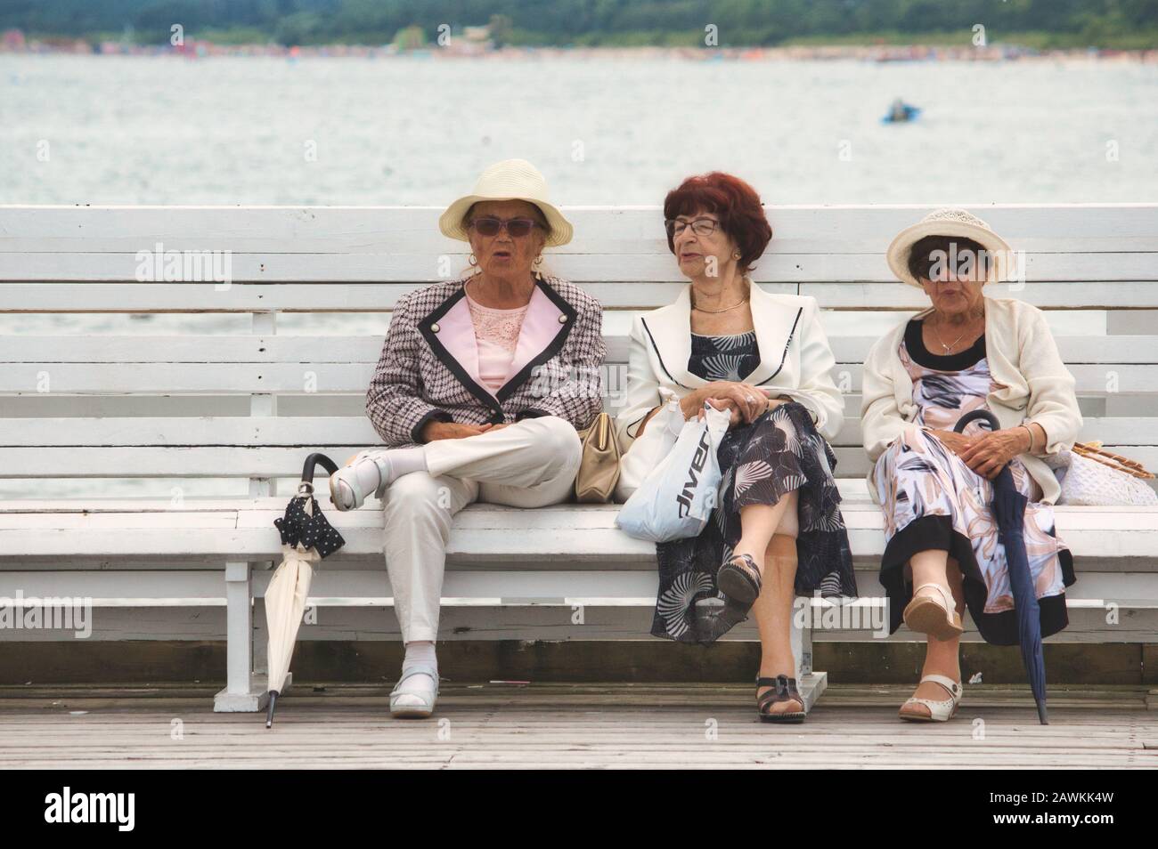 Sopot / Polen - 3. August 2019: Drei alte Damen saßen zusammen im Gespräch auf einer öffentlichen Bank am Strand Stockfoto