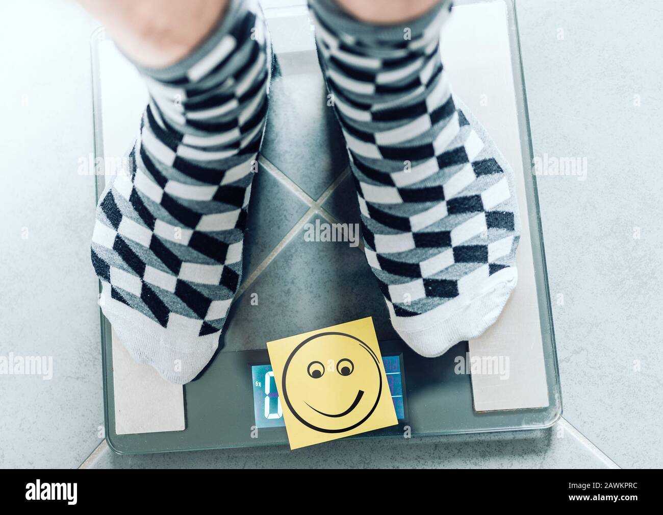 Nahaufnahme der Person in Socken auf der Badezimmer-Skala mit lächelndem Gesicht, ideales Körper-Wight-Konzept Stockfoto