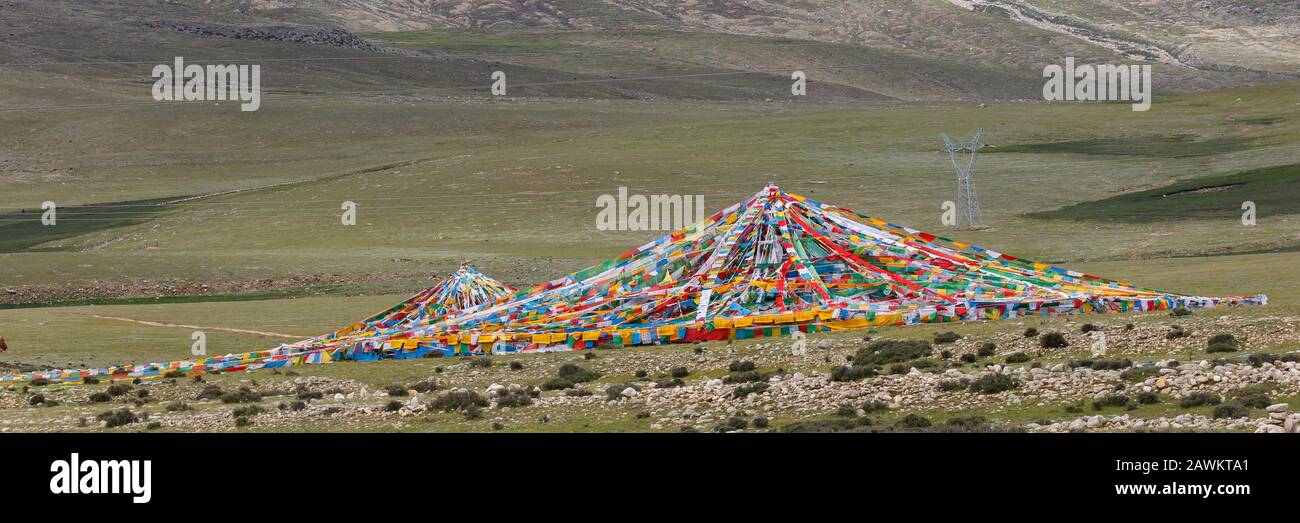 Panorama-Blick auf die zusammengebundenen und zu einem Dreieck/Zelt geformten Gebetflaggen. Gefangen in den Grasländern des tibetischen Plateaus. Stockfoto