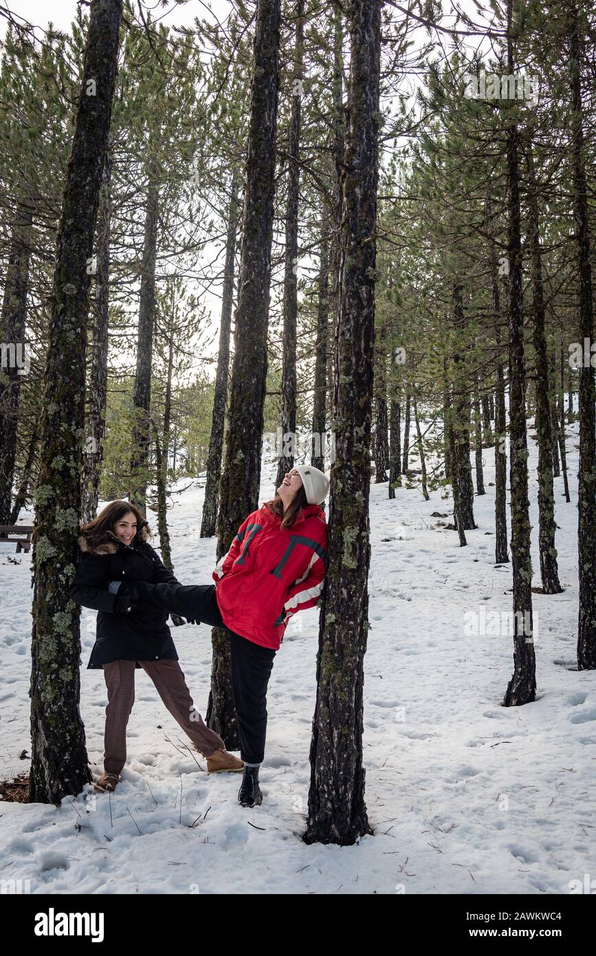 Junge fröhliche und schöne Mädchen im Teenager-Alter, die sich im Winter in Winterkleidung kleiden und im Schnee spielen. Troodos Berge auf Zypern Stockfoto