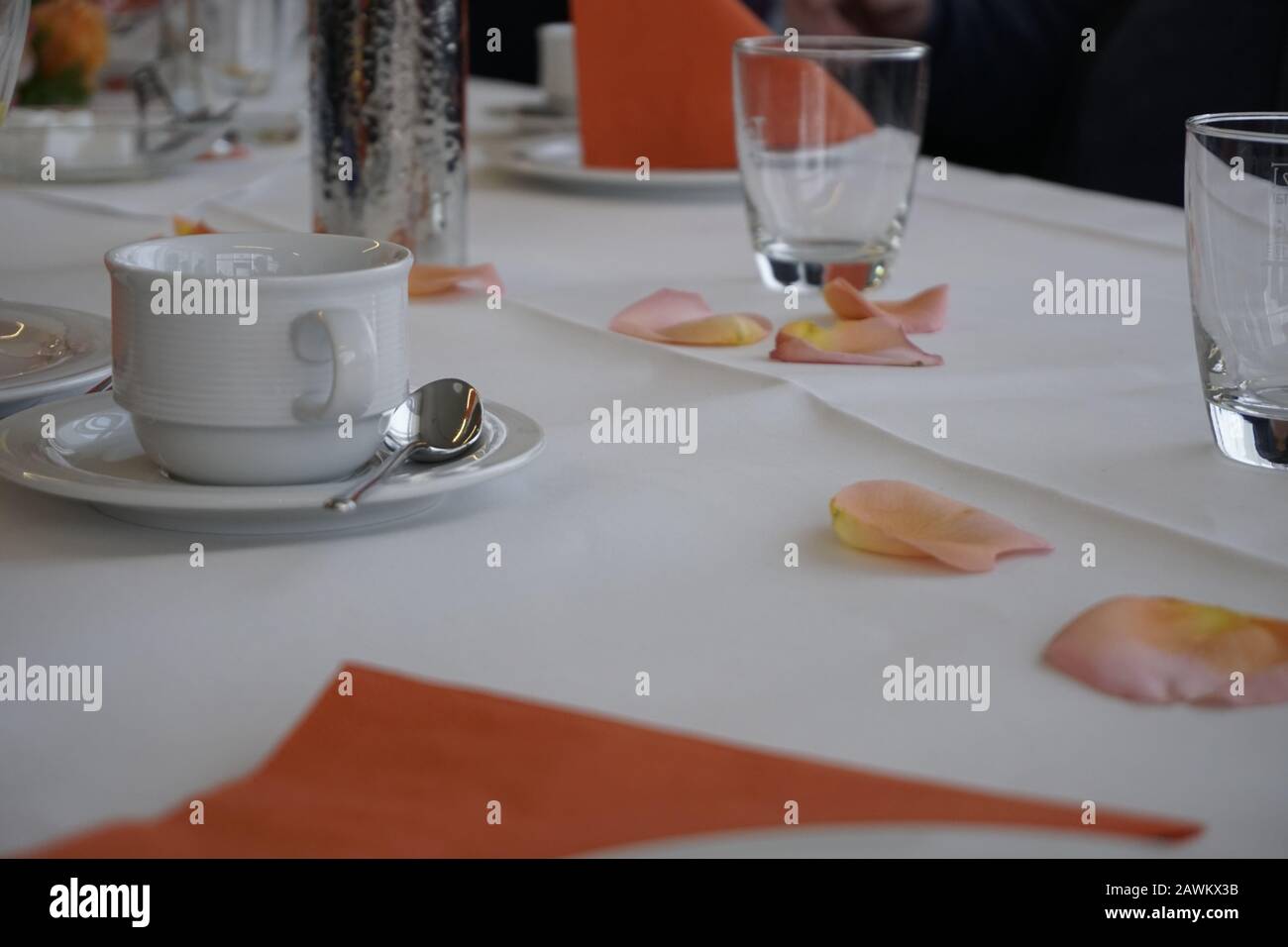 Tisch mit Rosenblättern und Geschirr Stockfoto