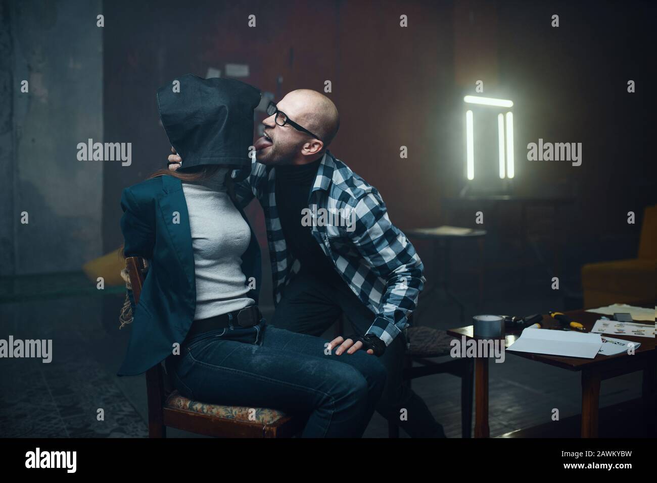 Maniak-Entführer leckt sein weibliches Opfer Stockfoto