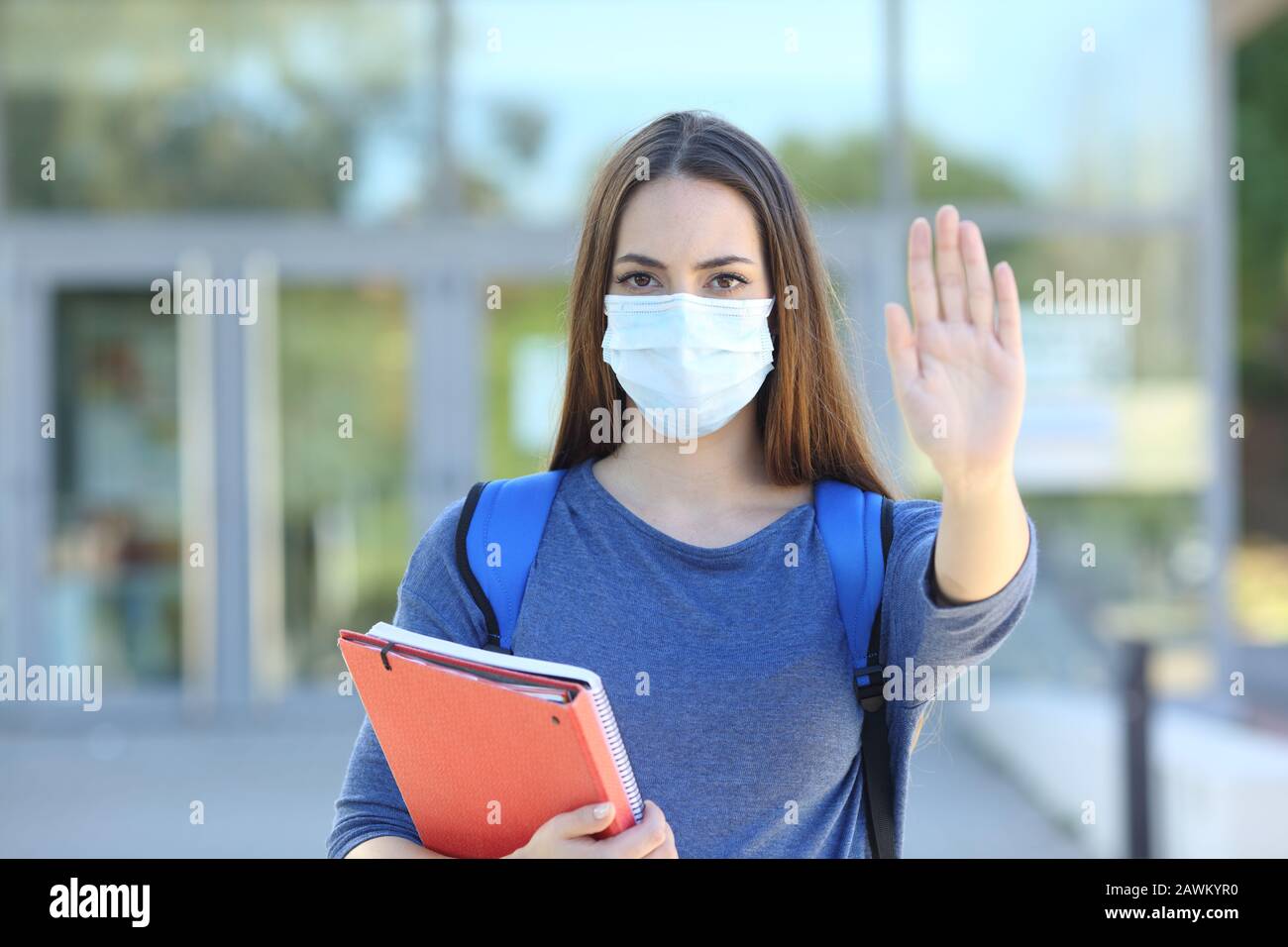 Vorderansicht eines Studenten mit einer Schutzmaske, die einen Halt in einem College-Campus trägt Stockfoto