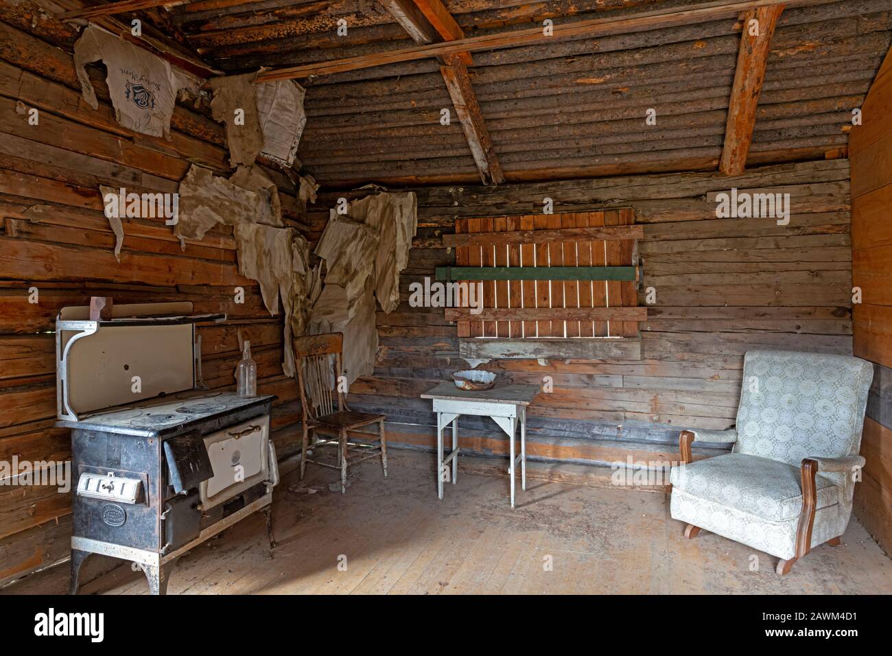 MT00496-00...MONTANA - Ein Sessel und ein Holzofen im stabilen Adams House in der Geisterstadt Garnet. Stockfoto