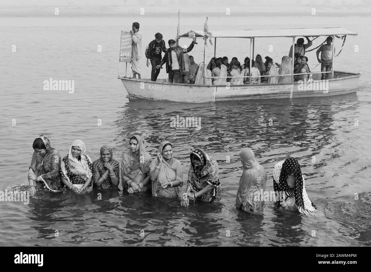 Hindu-Pilger in traditioneller Kleidung bieten rituelle Gebete im heiligen Fluss Yamuna bei Sonnenaufgang in Vrindavan, Uttar Pradesh, Indien. Stockfoto