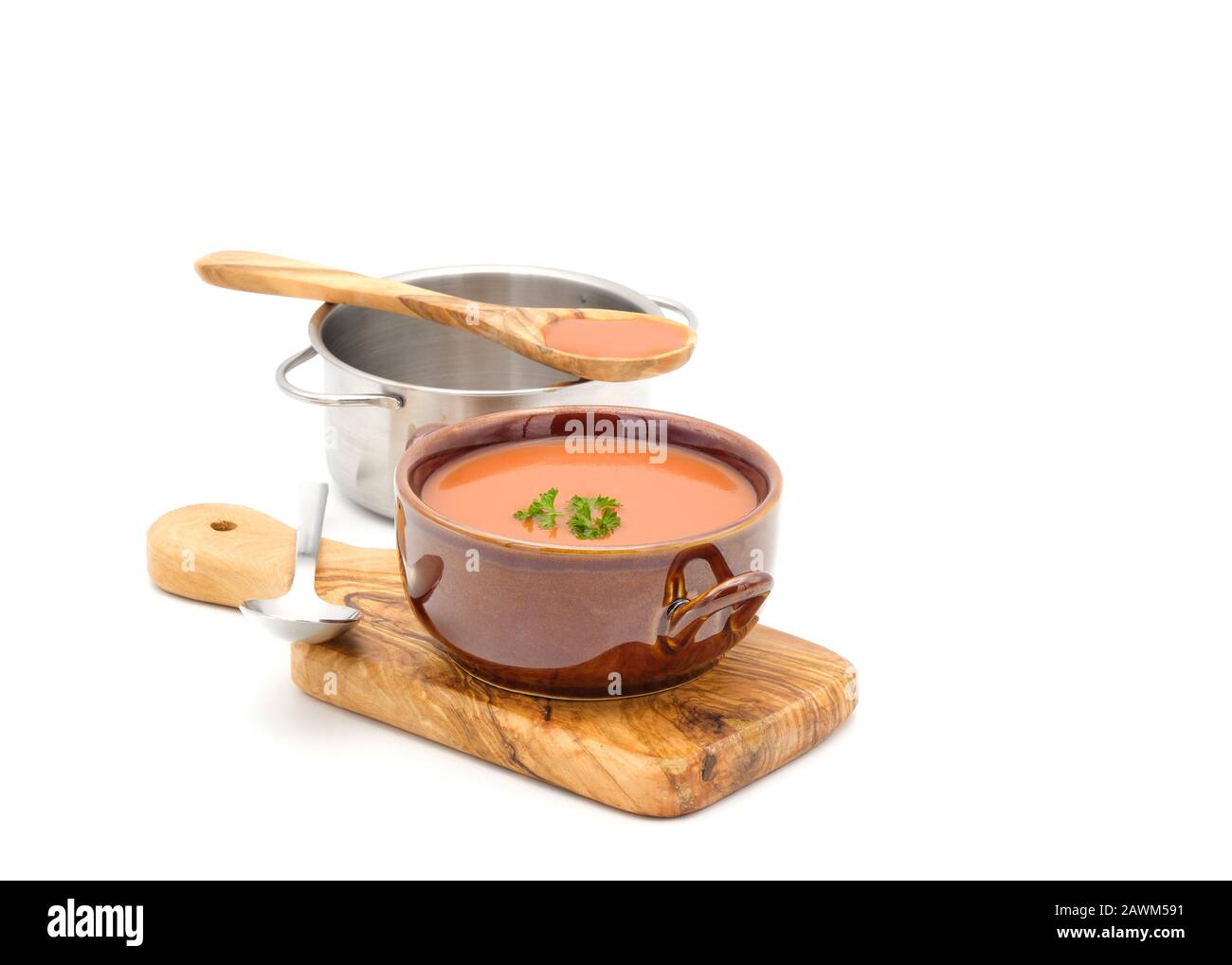 Schüssel mit köstlicher Tomatensuppe in einer rustikalen Schüssel, die auf weißem Hintergrund mit Kopierraum fotografiert wurde. Stockfoto