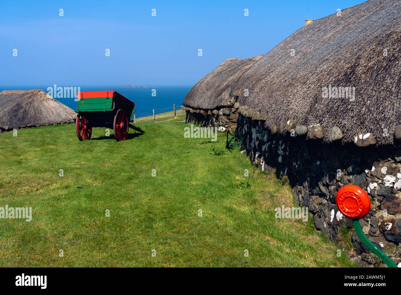 Insel Skye: Museum mit alten Hütten und Karren in der Natur in der Nähe des Ozeans mit dramatischem Himmel. Typisch für die Insel Skye Stockfoto