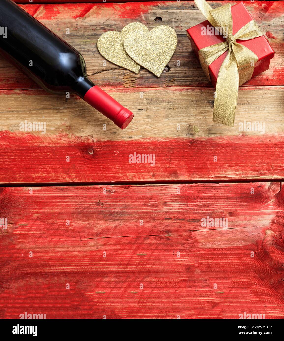 Valentines Tageskonzept. Rotweinflasche und ein Geschenk auf Holz, Draufsicht Stockfoto