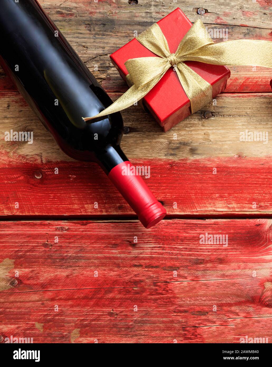 Valentines Tageskonzept. Rotweinflasche und ein Geschenk auf Holz, Draufsicht Stockfoto
