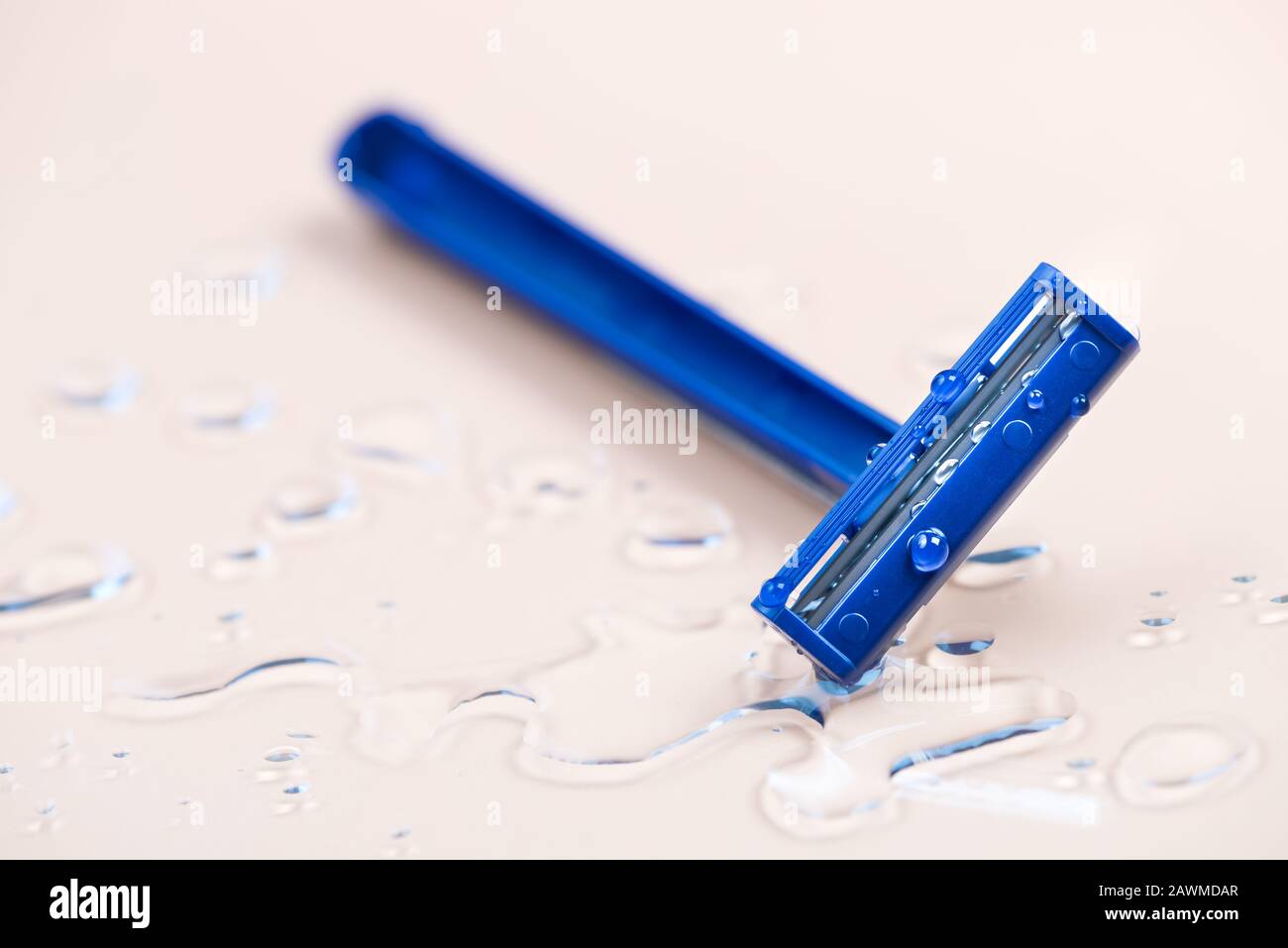 Rasiermesser auf nassem Pastellgrund mit Wassertropfen Stockfoto