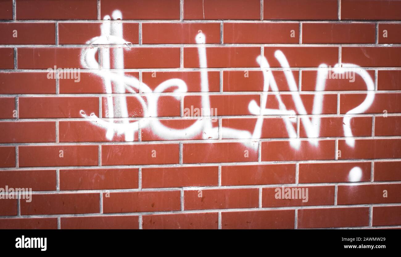 Word SCLAV mit weißem Farbspray an der Wand Stockfoto