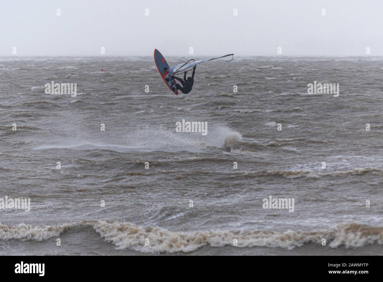 Ein Windsurfer, der auf rauer See in die Luft in der Themsemündung sprang, während der Sturm Ciara das Wetter in Southend on Sea, Essex, Großbritannien beeinträchtigt. In Der Luft Stockfoto