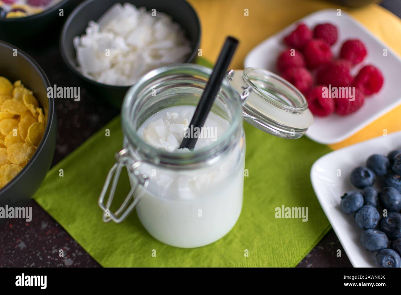 Bio-Kokosnussreisgetränk mit Kokosflocken im Konservierungsbecher mit Strohhalm Stockfoto