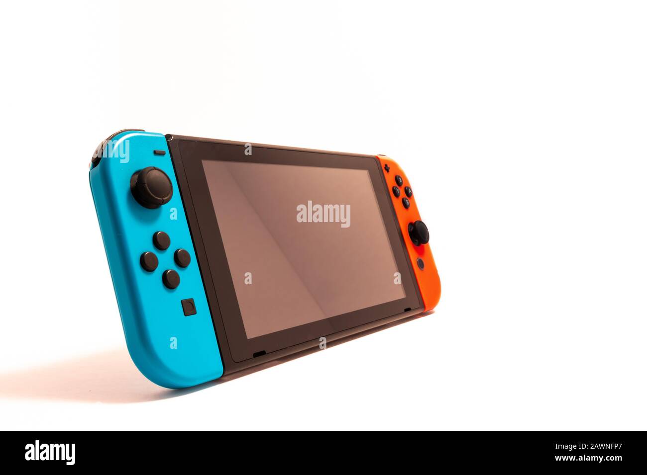 Eine Videospielkonsole von Nintendo Switch wird isoliert vor einem weißen Hintergrund gesehen, der mit einem Schatten aufsteht. Stockfoto