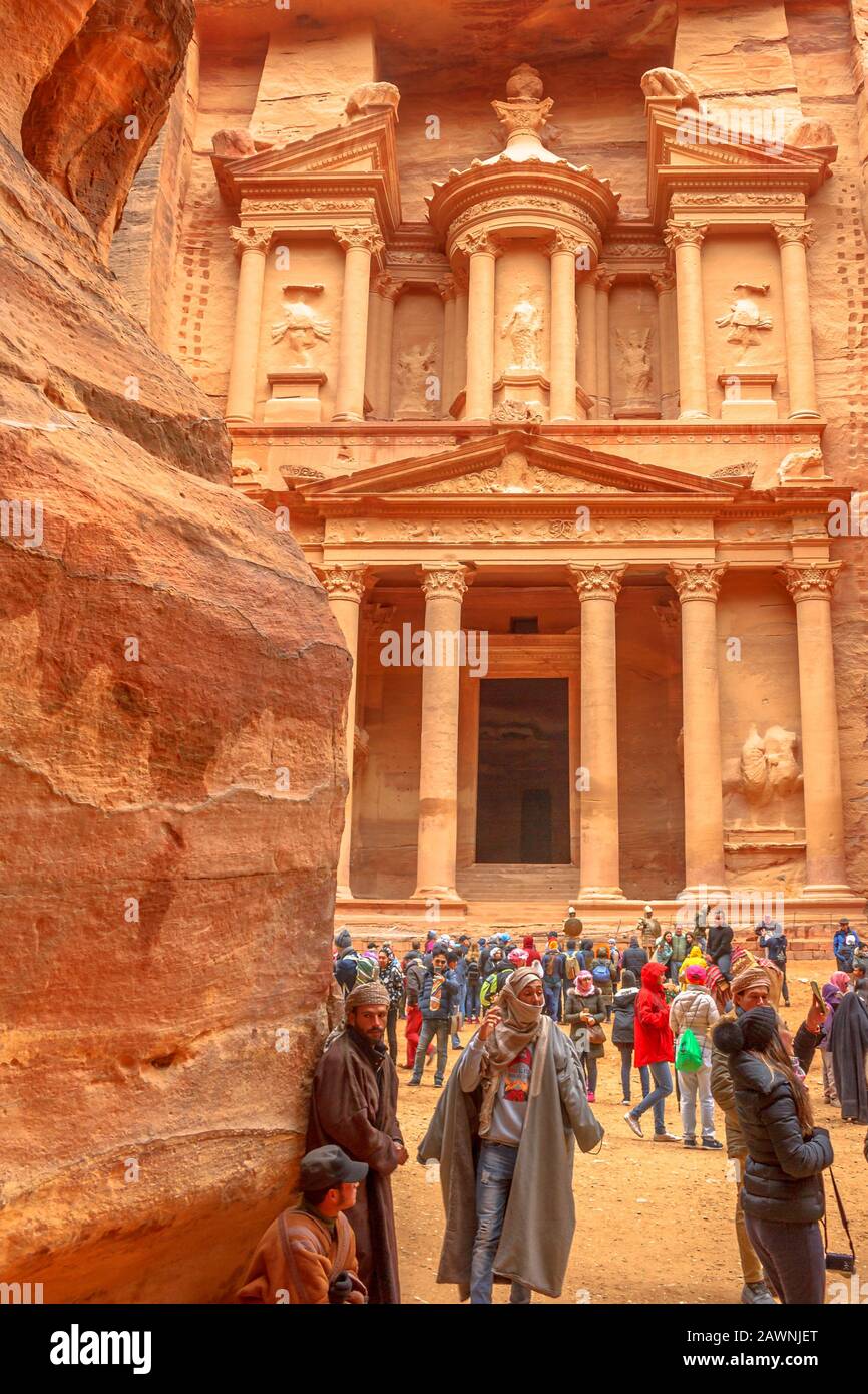 Petra, Jordanien - 4. Januar 2020: Touristen und Beduinen im Schatzamt von der Siq aus gesehen, dem Haupteingang zur alten Nabatäen-Stadt. Enge Schlucht, die mit endet Stockfoto