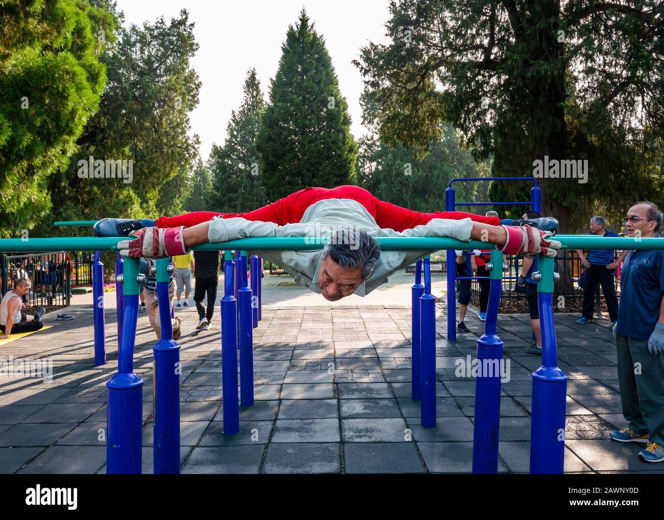 Der ältere Chinese trainiert im Outdoor-Fitnessstudio, in dem die Splits gemacht werden, Tiantan Park, Peking, China, Asien Stockfoto
