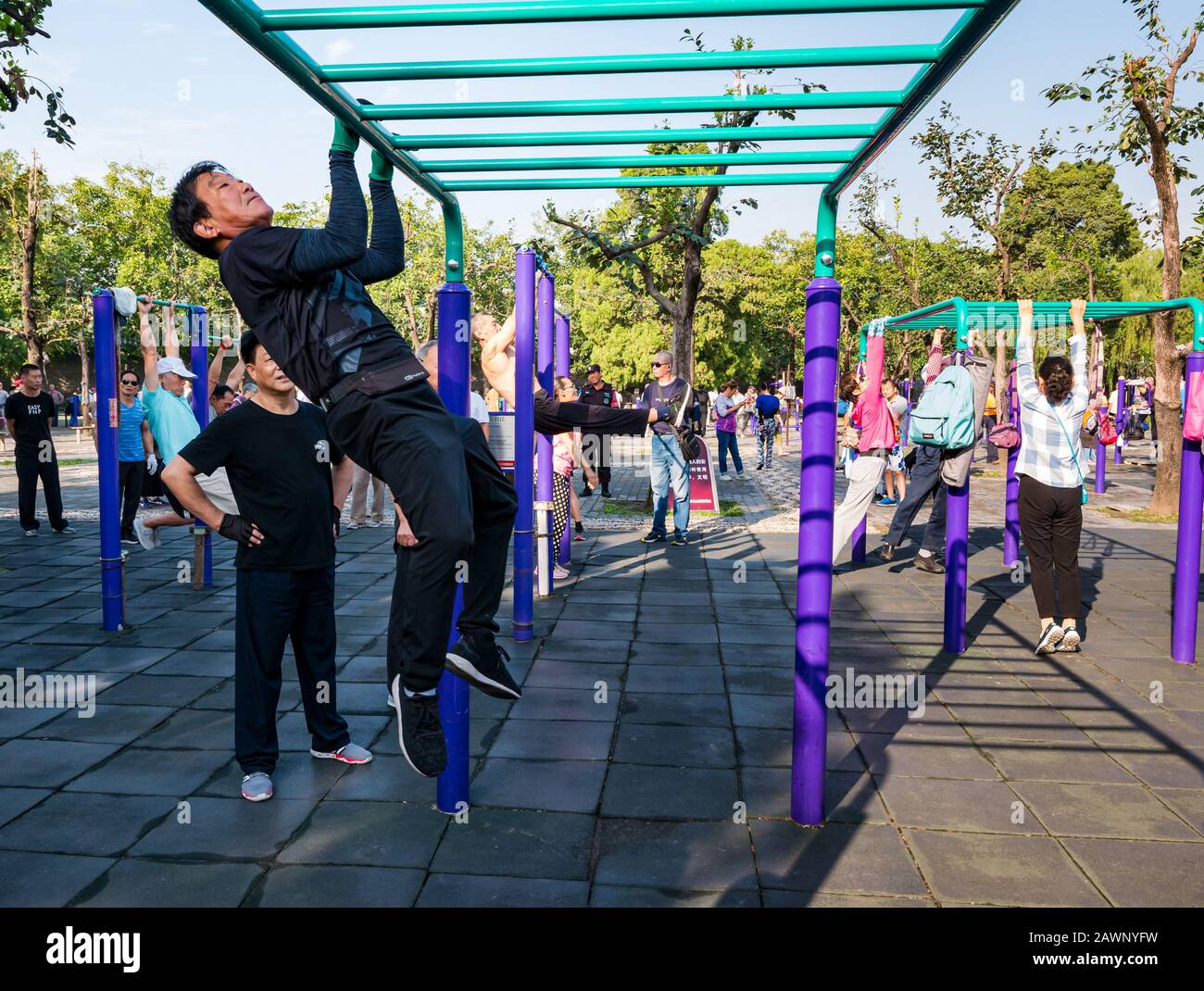Der ältere Chinese trainiert im Outdoor-Fitnessstudio, das auf Barschienen schwingt, im Tiantan Park, Peking, China, Asien Stockfoto