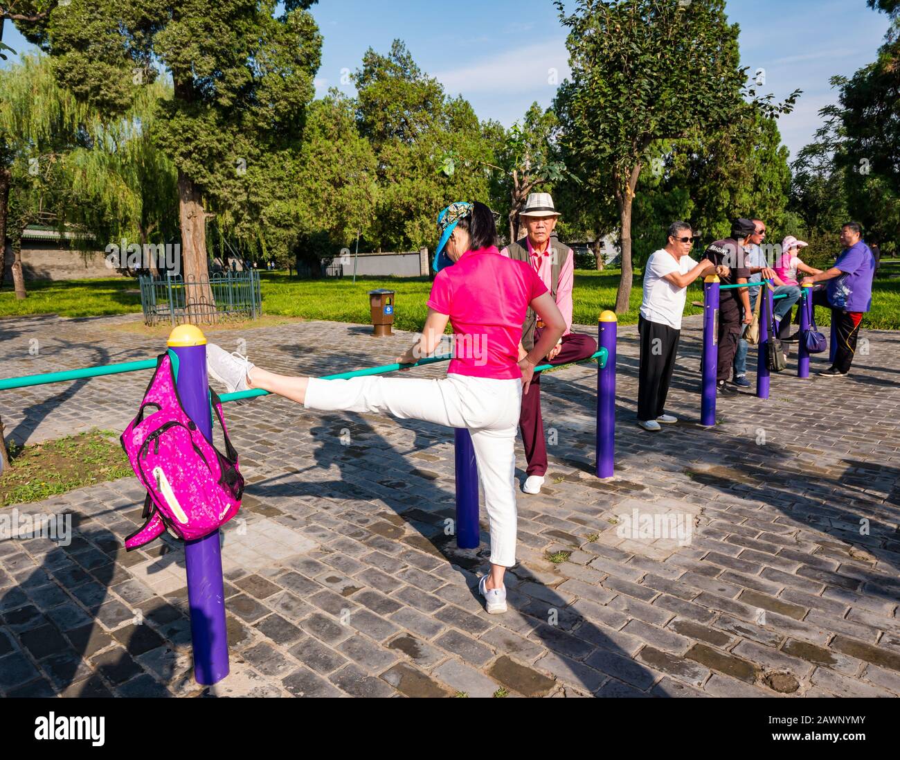 Ältere Chinesen trainieren im Outdoor-Fitnessstudio mit Frau Stretching Leg, Tiantan Park, Peking, China Stockfoto