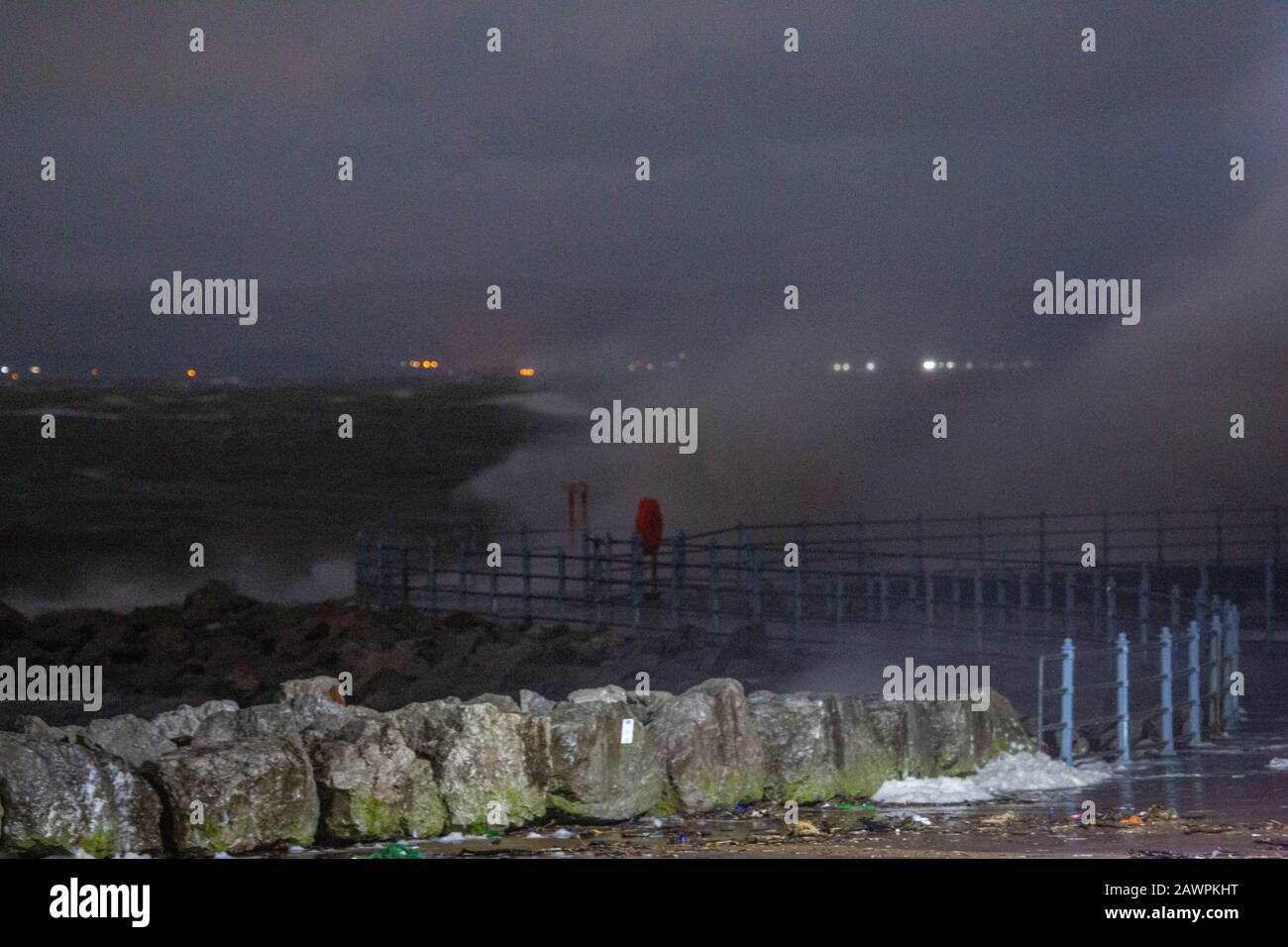 Grosvenor Break Water, Heysham, Lancashire, Großbritannien. Februar 2020. Heysham Hightidde heute Abend hat mehr Wellen über die Spitze des Breakwater mit He Lights of Ulverston im Hintergrund Credit gebracht: Photographing North/Alamy Live News Stockfoto