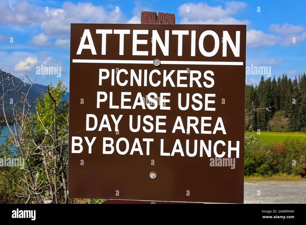 Ein aufmerksames Picknickkicker verwendet ein Schild mit dem Tagesbereich Stockfoto