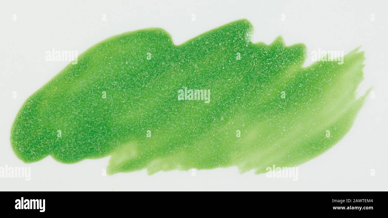 Glitzernde grüne Farbflecke isoliert auf weißem Hintergrund Nahansicht Stockfoto