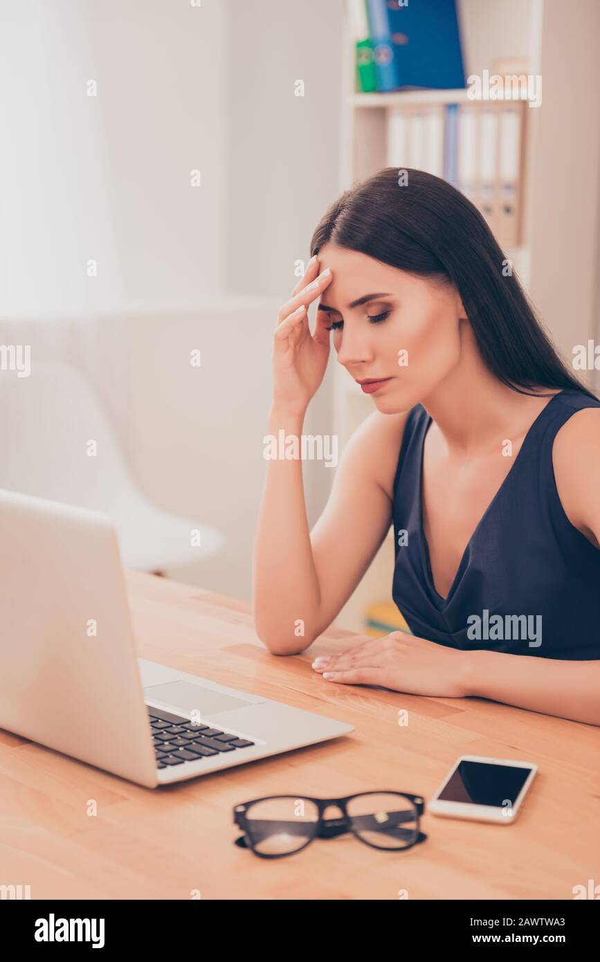 Porträt der jungen, müden Geschäftsfrau, die im Büro Kopfschmerzen hat Stockfoto