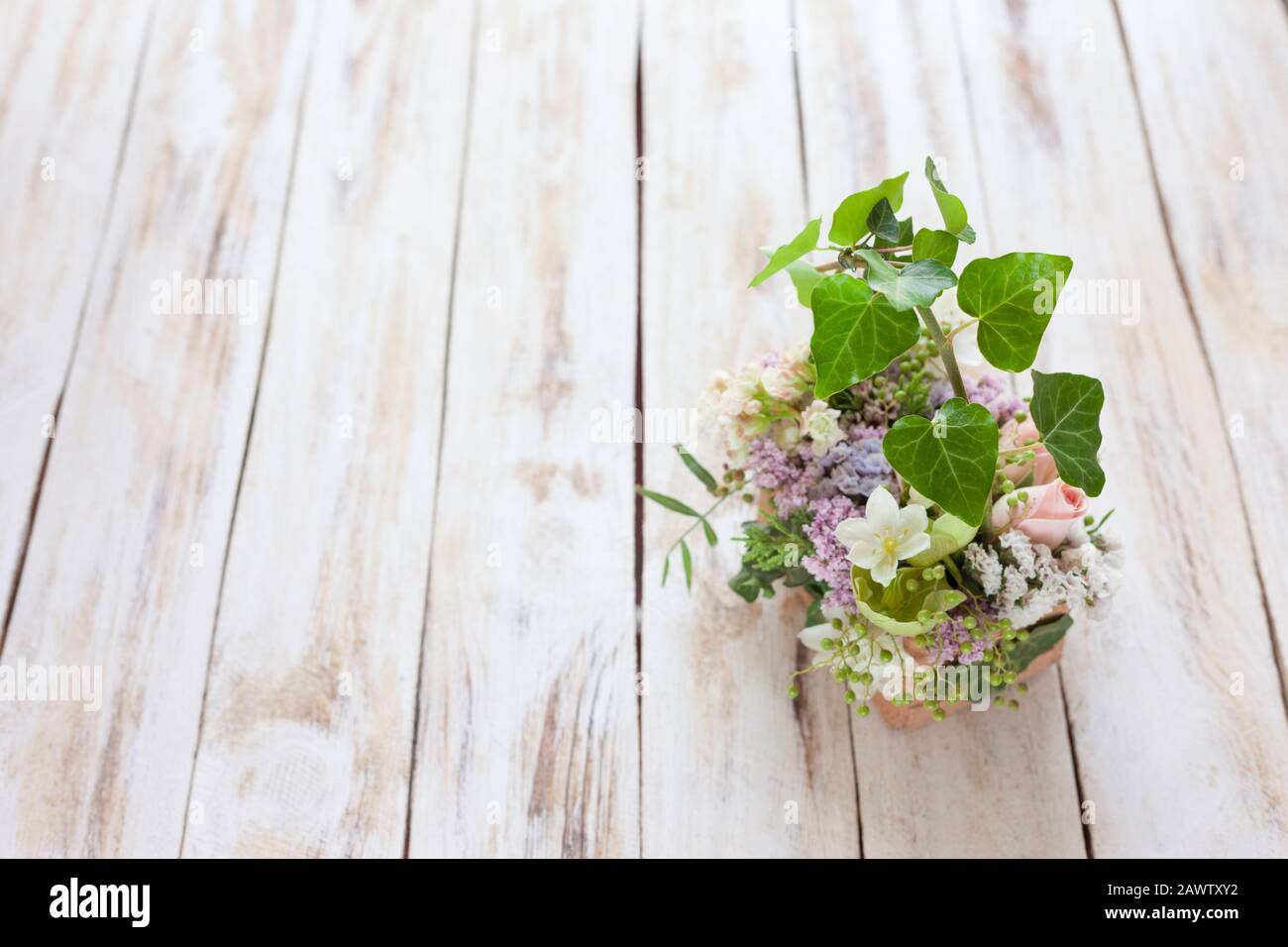 Blumenstrauß auf einem alten hellen schäbigen, schicken Holzhintergrund. Platz für Text. Stockfoto