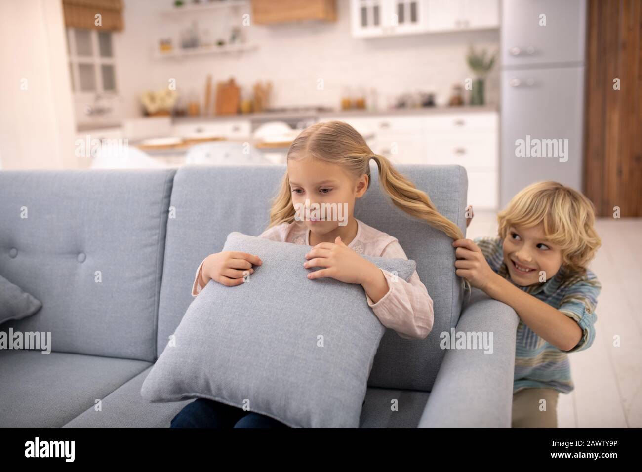 Junge ziehen Mädchen Pferdeschwanz von hinten und lächeln Stockfoto